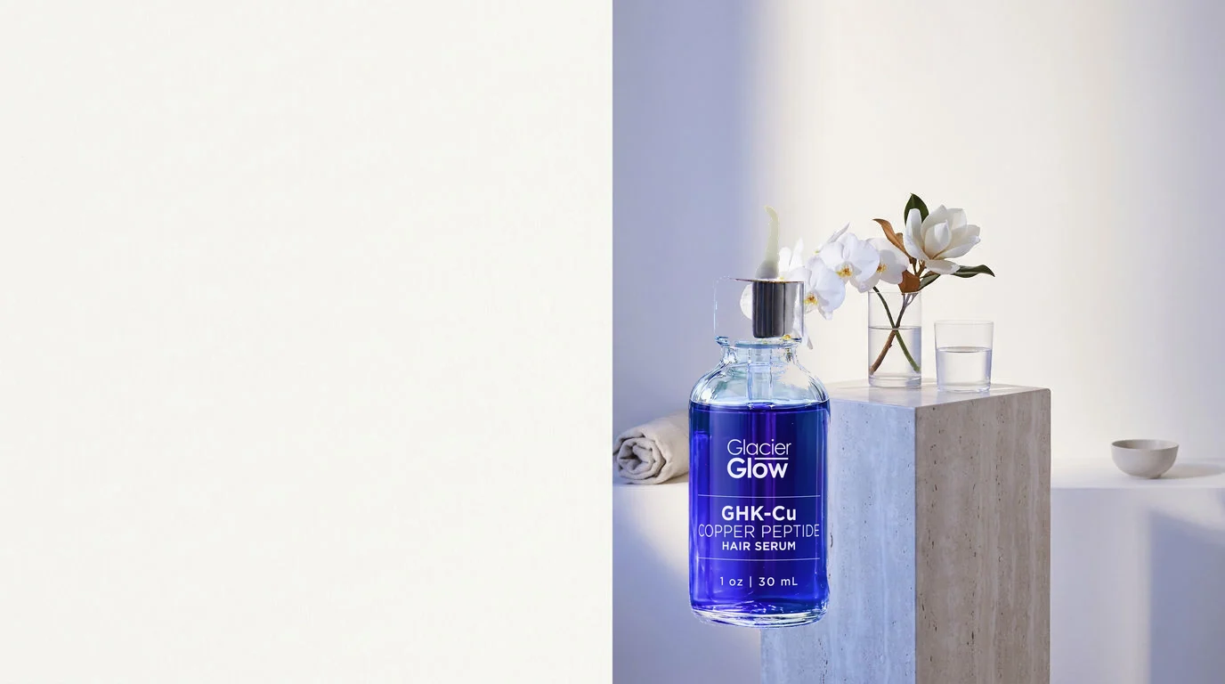 The GlacierGlow GHK-Cu serum bottle on a travertine pedestal with white magnolia blossoms and a glass of water in soft daylight